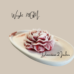 A detailed peony flower-shaped soy wax candle in a rose scent, displayed on a decorative tray.