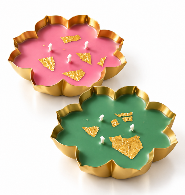 Pink and green lotus-shaped decorative candles in gold metal tins with three wicks and elegant gold leaf accents, displayed on a clean white background.