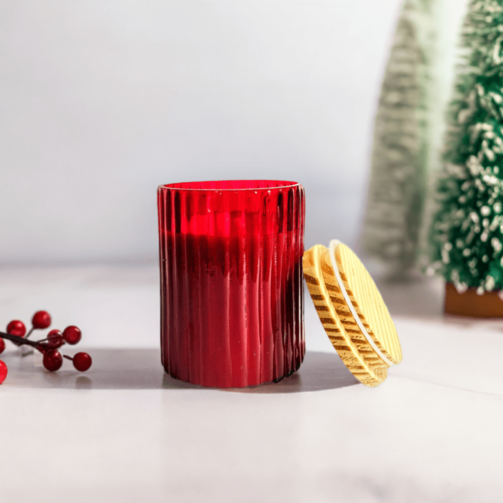 Red glass jar candle with lid, festive holiday decor.