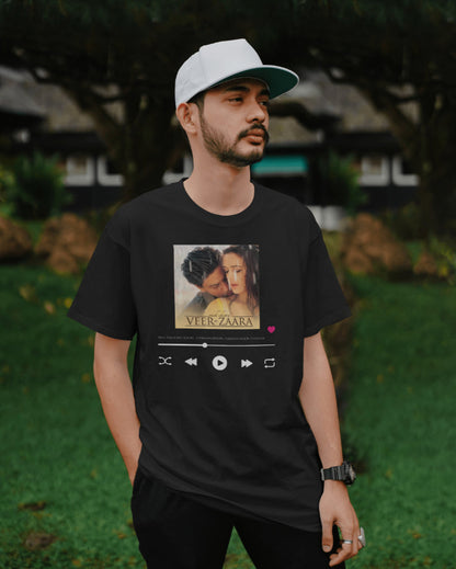 A male model with a white cap wearing oversized Unisex 'Veer Zaara Graphic' Black T-shirt 