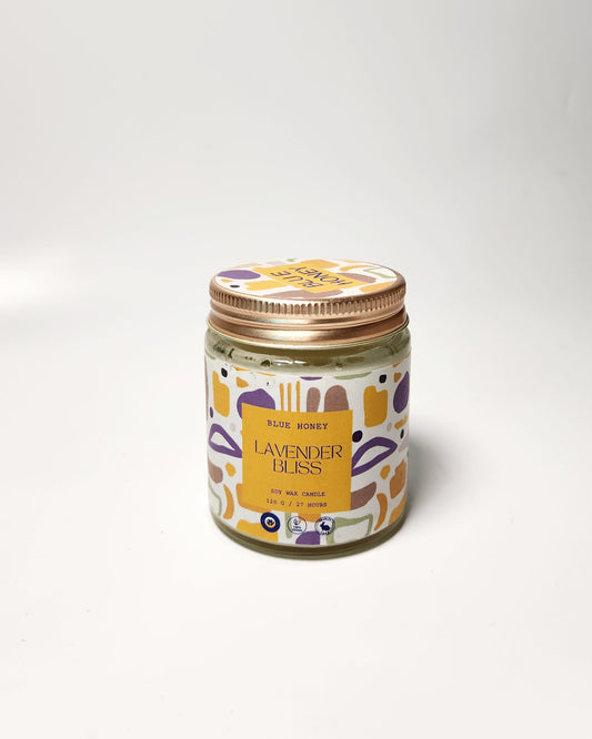 Jar of lavender candle with a colorful label on a white background