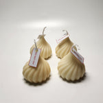 Four ivory modak-shaped candles with 'Do Not Eat' tags, presented from a front-facing perspective.