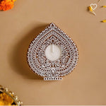 Handcrafted wooden carved tealight holder with intricate white patterns, holding a white tealight candle.