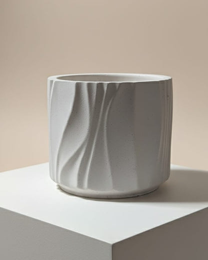 white ceramic candle jar with marbled texture on a white surface against a beige background