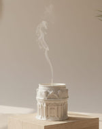 White Grand Pavilion architectural jesmonite candle jar with intricate detailing, emitting smoke.
