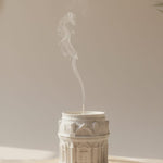 White Grand Pavilion architectural jesmonite candle jar with intricate detailing, emitting smoke.