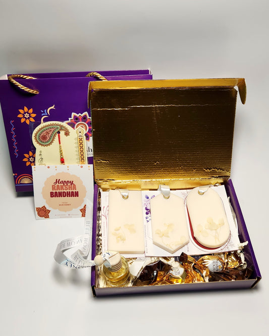 Gift set with wax sachet and car diffuser and snacks in a decorative box on a white background