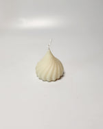 A white, swirl-shaped modak candle, perfect for Ganesh Chaturthi or as a unique gift.