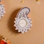 Handcrafted wooden carved tealight holder with intricate paisley design, holding a white tealight candle.