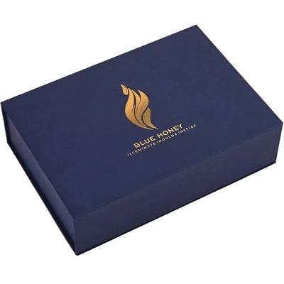 A dark blue rectangular gift box with a gold honeycomb logo and the text 'BLUE HONEY' on the lid, shown at an angle on a white background.