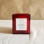 Front view of a red glass jar candle labeled 'Gingerbread' from the Christmas Candle Collection.