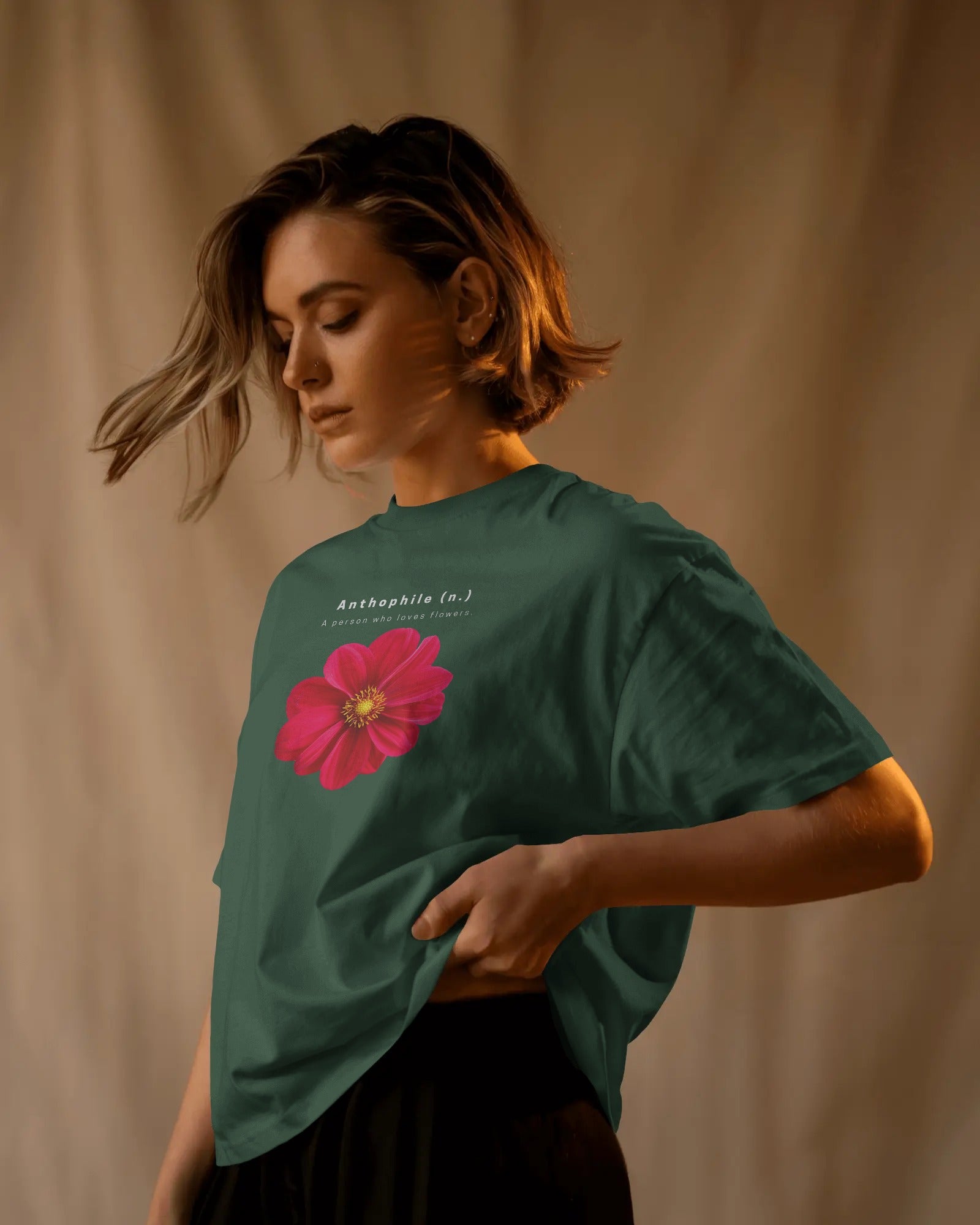 a feamle model standing showing side pose of an oversized Bottle Green Anthophile tshirt 