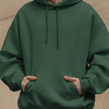 Front view of the Dreamin' Oversized Unisex Hoodie in green, featuring a comfortable and casual streetwear style.