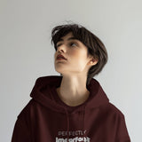 Maroon Perfectly Imperfect heavyweight oversized hooded sweatshirt with minimalist typography logo on the front.