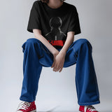 Oversized black graphic t-shirt featuring Diljit Dosanjh's 'Diluminati' design, worn by a person sitting.