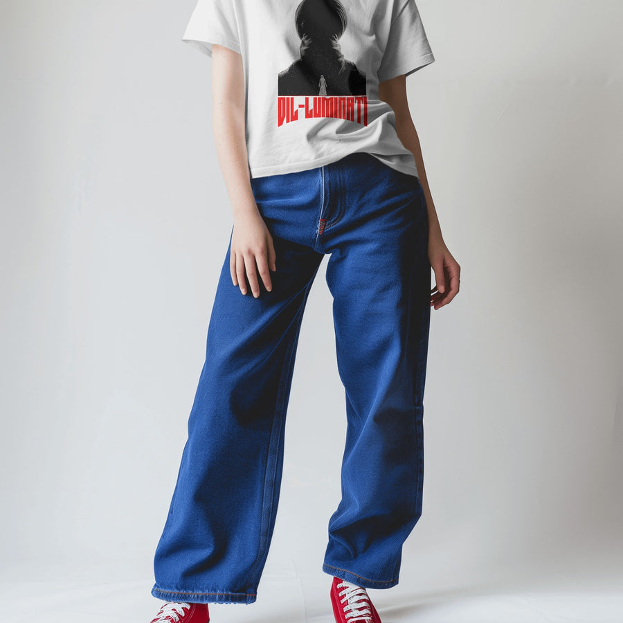 Oversized white Diljit Dosanjh 'Diluminati' graphic t-shirt worn by a person in blue jeans and red sneakers.