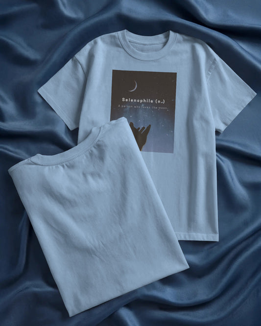 oversized baby blue Selenophile tshirt laying on a blue sheet in the background