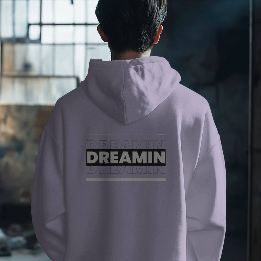 Back view of a Dreamin oversized unisex hoodie in a light purple color with graphic text.