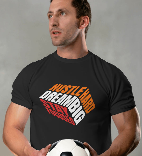 Black t-shirt with 'Hustle Hard Dream Big Stay Focused' graphic, worn by a man holding a soccer ball.