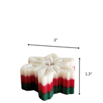 A snowflake-shaped Christmas candle with red, green, and white layers, measuring 3 inches wide and 1.3 inches tall.