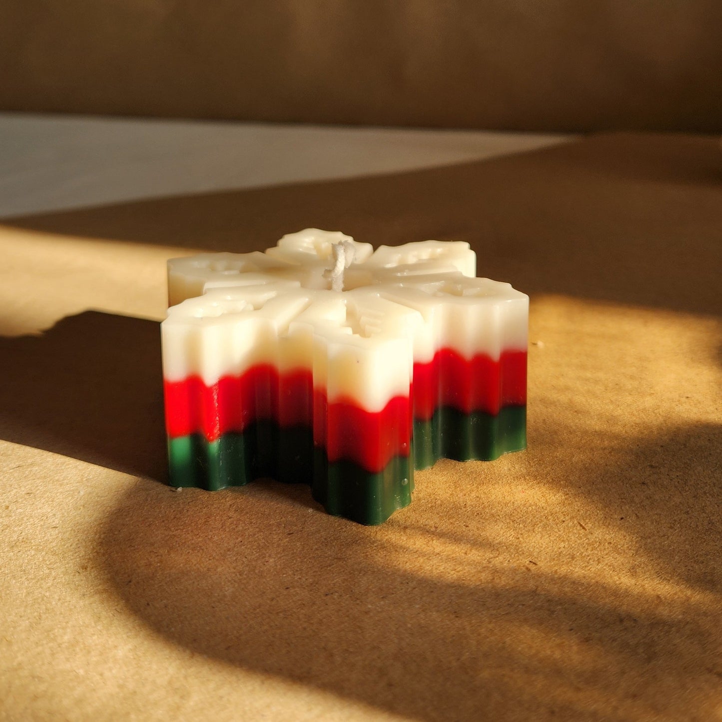 snowflake candle in Christmas colors on table top