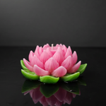 The Purity Lotus Candle in pink and green, a handmade floating candle with detailed petals, shown from the front.