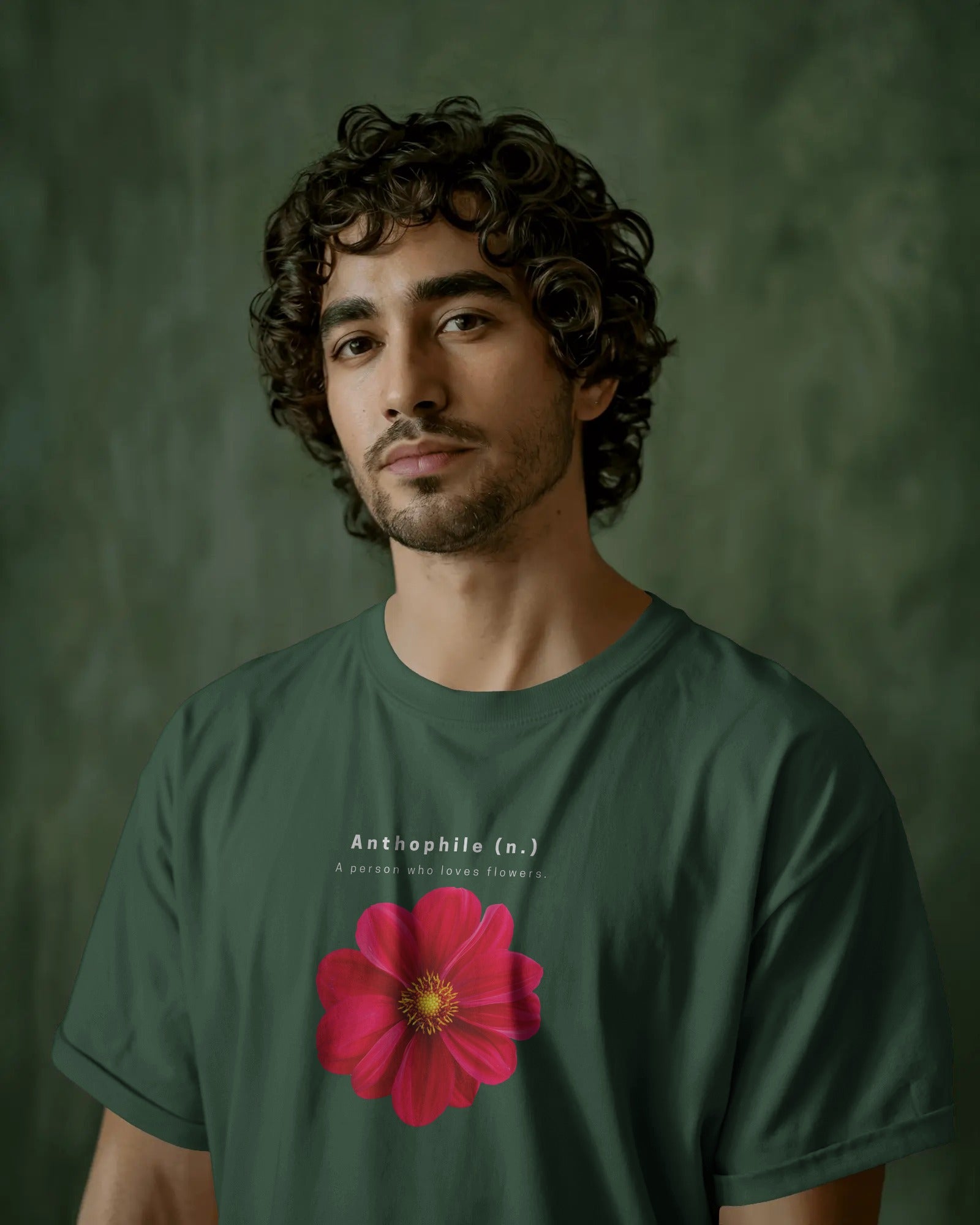 a middle eastern make model with curly hair wearing an oversized Bottle Green Anthophile tshirt