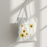 White canvas tote bag with a minimalist sunflower print, perfect for eco-friendly shopping and everyday style.