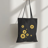 Black eco-friendly tote bag with a stylish sunflower print, perfect for shopping and everyday use.