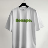 White unisex oversized t-shirt featuring the word "Escape" in a green maze-like typography design.