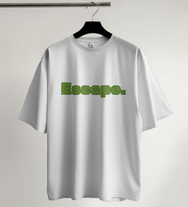White unisex oversized t-shirt featuring the word "Escape" in a green maze-like typography design.