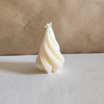 A white Christmas tree-shaped soy wax pillar candle with a twisted design, perfect for holiday decor.