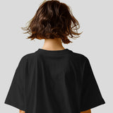 Back view of an oversized black Diljit Dosanjh 'Diluminati' t-shirt with wavy brown hair.