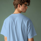 Selenophile minimalist oversized baby blue cotton t-shirt, shown from the back on a young man.